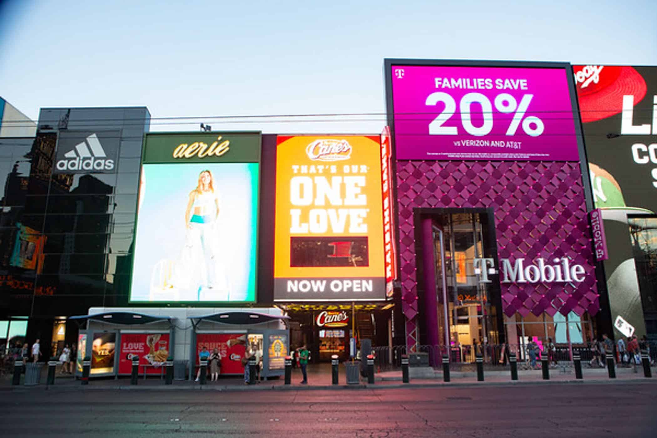 rendering of people waiting at a bus stop with a row of stores and restaurants behind them