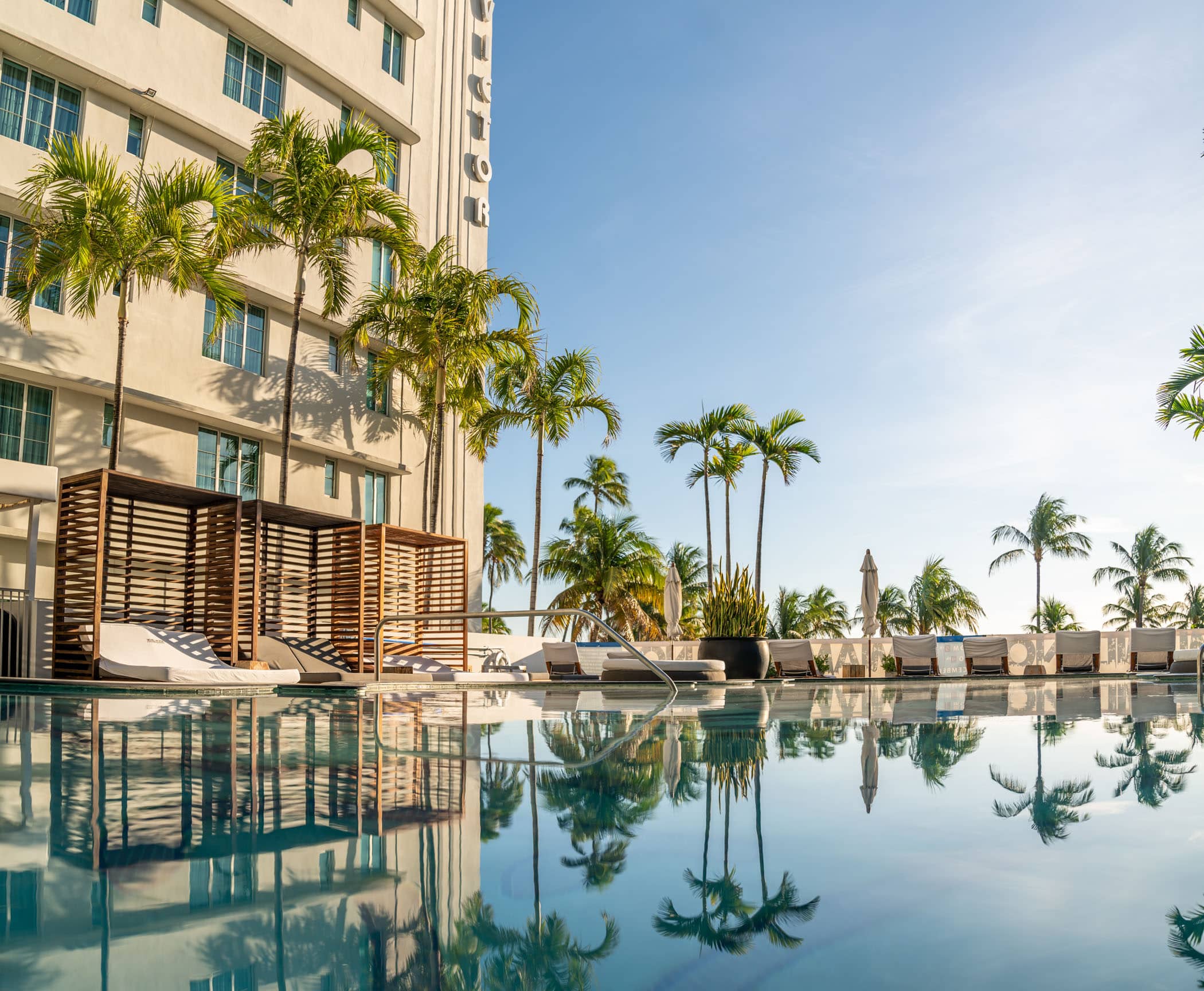 hotel pool surrounded by lounge chairs and palm trees